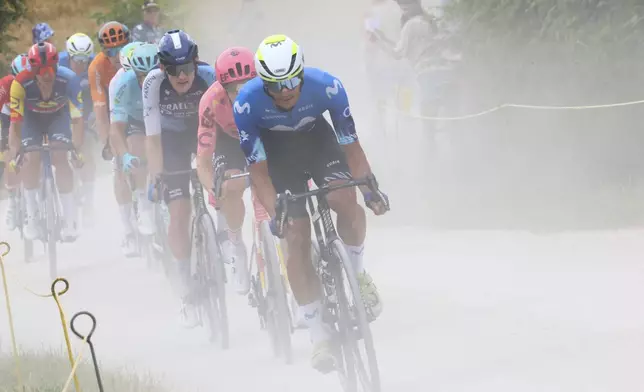 Spain's Javier Romo leads the breakaway group with Canada's Derek Gee in third position as they ride on a gravel road during the ninth stage of the Tour de France cycling race over 199 kilometers (123.7 miles) with start and finish in Troyes, France, Sunday, July 7, 2024. (Etienne Garnier/Pool Photo via AP)