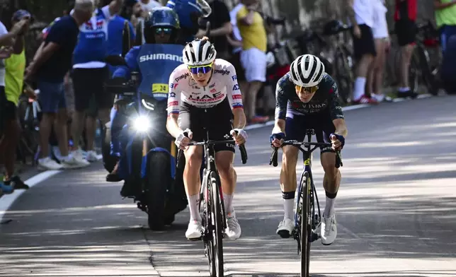 Slovenia's Tadej Pogacar, left, and Denmark's Jonas Vingegaard break away from the pack during the second stage of the Tour de France cycling race over 199.2 kilometers (123.8 miles) with start in Cesenatico and finish in Bologna, Italy, Sunday, June 30, 2024. (Bernard Papon/Pool Photo via AP)