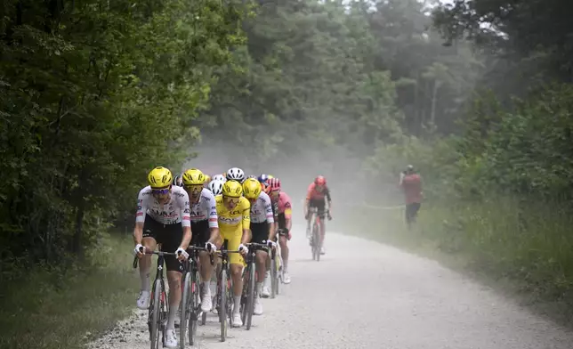 Slovenia's Tadej Pogacar, wearing the overall leader's yellow jersey, follows his teammates on a gravel road during the ninth stage of the Tour de France cycling race over 199 kilometers (123.7 miles) with start and finish in Troyes, France, Sunday, July 7, 2024. (Bernard Papon/Pool Photo via AP)