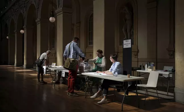 A voter casts his ballot during the second round of the legislative elections, in Lyon, central France, Sunday, July 7, 2024. France votes Sunday in pivotal runoff elections that could hand a historic victory to Marine Le Pen's far-right National Rally and its inward-looking, anti-immigrant vision — or produce a hung parliament and years of political deadlock. (AP Photo/Laurent Cipriani)