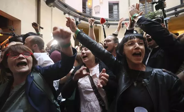 Supporters of the far-left La France Insoumise - LFI - (France Unbowed) parry react at the party election night headquarters, Sunday, July 7, 2024 in Paris. A coalition on the left that came together unexpectedly ahead of France's snap elections won the most parliamentary seats in the vote, according to polling projections Sunday. The surprise projections put President Emmanuel Macron's centrist alliance in second and the far right in third. At left is LFI's Mathilde Pant and at center Manuel Bompard. (AP Photo/Thomas Padilla)