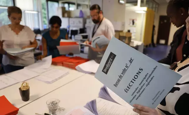 Local city officials prepare voting kits for the legislative election in Strasbourg, eastern France, on Saturday, July 6, 2024. Voters face a decisive choice in the runoff Sunday of snap parliamentary elections that could produce the country’s first far-right government since the World War II Nazi occupation. (AP Photo/Jean-Francois Badias)