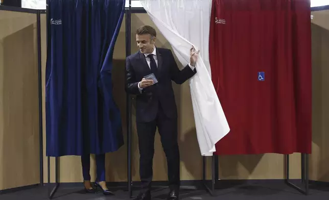 French President Emmanuel Macron and his wife Brigitte Macron leave the voting booth before voting for the second round of the legislative elections in Le Touquet-Paris-Plage, northern France, Sunday July 7 2024. Voting has begun in mainland France on Sunday in pivotal runoff elections that could hand a historic victory to Marine Le Pen's far-right National Rally and its inward-looking, anti-immigrant vision — or produce a hung parliament and political deadlock. (Mohammed Badra, Pool via AP)