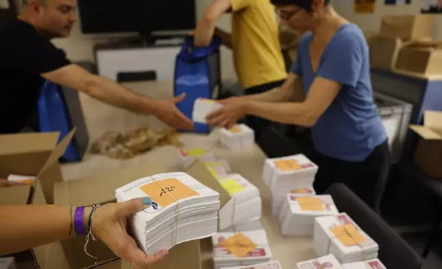 Local city officials prepare voting kits for the legislative election in Strasbourg, eastern France, on Saturday, July 6, 2024. Voters face a decisive choice in the runoff Sunday of snap parliamentary elections that could produce the country’s first far-right government since the World War II Nazi occupation. (AP Photo/Jean-Francois Badias)