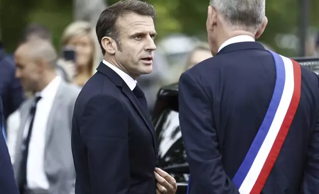 French President Emmanuel Macron, center, talks with Le Touquet mayor Daniel Fasquelle as he arrives to vote for the second round of the legislative elections in Le Touquet-Paris-Plage, northern France, Sunday July 7 2024. Voting has begun in mainland France on Sunday in pivotal runoff elections that could hand a historic victory to Marine Le Pen's far-right National Rally and its inward-looking, anti-immigrant vision — or produce a hung parliament and political deadlock. (Mohammed Badra, Pool via AP)