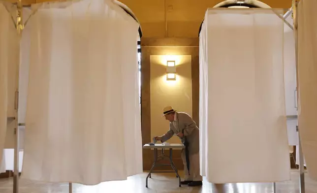 A man votes in the second round of the legislative elections, Sunday, July 7, 2024 in Strasbourg, eastern France. France votes Sunday in pivotal runoff elections that could hand a historic victory to Marine Le Pen's far-right National Rally and its inward-looking, anti-immigrant vision — or produce a hung parliament and years of political deadlock. (AP Photo/Jean-Francois Badias)