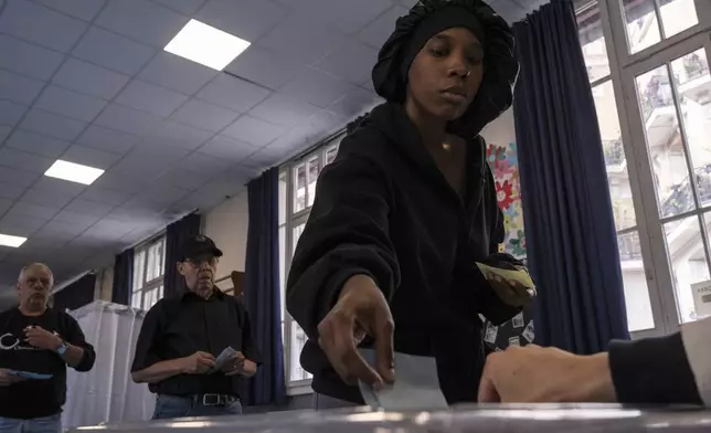 A voter casts her ballot during the second round of the legislative elections, Sunday, July 7, 2024 in Paris. France votes Sunday in pivotal runoff elections that could hand a historic victory to Marine Le Pen's far-right National Rally and its inward-looking, anti-immigrant vision — or produce a hung parliament and years of political deadlock. (AP Photo/Louise Delmotte)