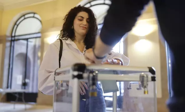 A woman casts her ballot in the second round of the legislative elections, Sunday, July 7, 2024 in Strasbourg, eastern France. France votes Sunday in pivotal runoff elections that could hand a historic victory to Marine Le Pen's far-right National Rally and its inward-looking, anti-immigrant vision — or produce a hung parliament and years of political deadlock. (AP Photo/Jean-Francois Badias)