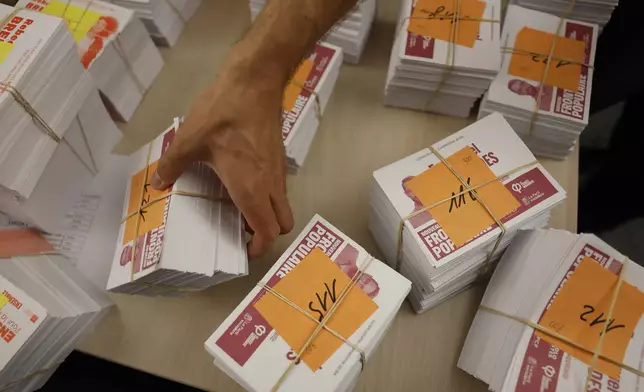 Local city officials prepare voting kits for the legislative election in Strasbourg, eastern France, on Saturday, July 6, 2024. Voters face a decisive choice in the runoff Sunday of snap parliamentary elections that could produce the country’s first far-right government since the World War II Nazi occupation. (AP Photo/Jean-Francois Badias)