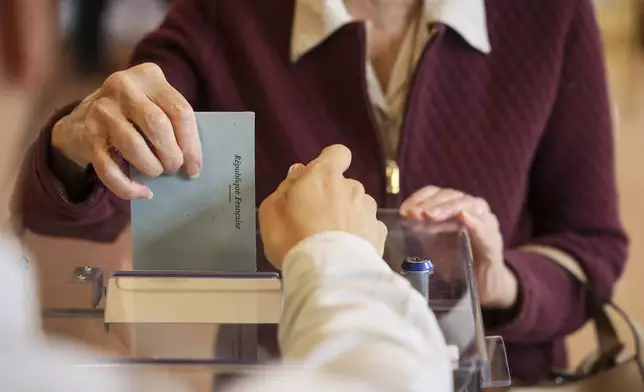 A woman casts her ballot during the second round of the legislative elections, Sunday, July 7, 2024 in Paris. Voting has begun in mainland France on Sunday in pivotal runoff elections that could hand a historic victory to Marine Le Pen's far-right National Rally and its inward-looking, anti-immigrant vision — or produce a hung parliament and years of political deadlock. (AP Photo/Thomas Padilla)