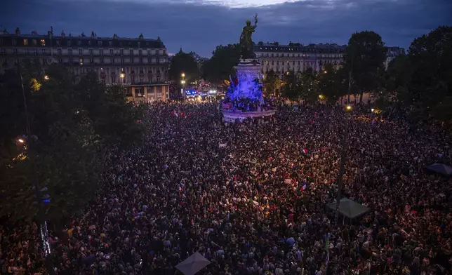 People gather at the Republique plaza after the second round of the legislative election, Sunday, July 7, 2024 in Paris. Surprise polling projections in France say a leftist coalition that came together to try to keep the far right from power has won the most parliamentary seats in runoff elections. There was high voter turnout. (AP Photo/Louise Delmotte)