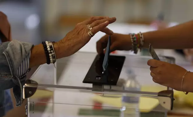 A woman casts her ballot in the second round of the legislative elections, Sunday, July 7, 2024 in Rennes, western France. (AP Photo/Jeremias Gonzalez)