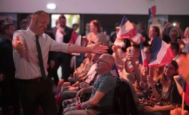 Local far-right mayor Steeve Briois, left, reacts after the release of projections based on the actual vote count in select constituencies , Sunday, June 30, 2024 in Henin-Beaumont, northern France. France's high-stakes legislative elections propelled the far-right National Rally to a strong but not decisive lead in the first-round vote Sunday, polling agencies projected, dealing another slap to centrist President Emmanuel Macron. (AP Photo/Thibault Camus)