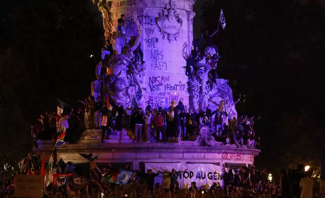 People gather at the statue on Republique plaza following the second round of the legislative elections, Sunday, July 7, 2024 in Paris. A coalition of the French left that quickly banded together to beat a surging far right in legislative elections won the most seats in parliament but not a majority, according to polling projections Sunday, a stunning outcome that threatens to plunge the country into political and economic turmoil. (AP Photo/Aurelien Morissard)