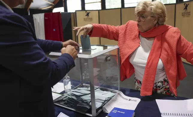 A woman casts her ballot during the second round of the legislative elections in Le Touquet-Paris-Plage, northern France, Sunday July 7 2024. Voting has begun in mainland France on Sunday in pivotal runoff elections that could hand a historic victory to Marine Le Pen's far-right National Rally and its inward-looking, anti-immigrant vision — or produce a hung parliament and political deadlock. (Mohammed Badra, Pool via AP)