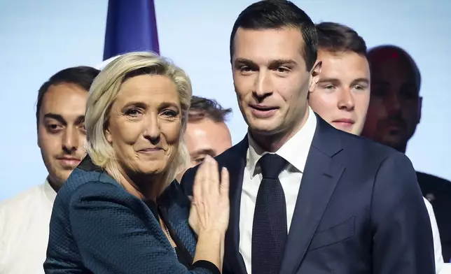 FILE - Leader of the French far-right National Rally Marine Le Pen, left, and lead candidate of the party for the upcoming European election Jordan Bardella during a political meeting on June 2, 2024 in Paris. At just 28 years old, Jordan Bardella has led the French far right to a landslide victory in the European Parliament election in June. After voters propelled Marine Le Pen's National Rally to a strong lead in the first round of national legislative elections on Sunday, Bardella has turned to rallying supporters to grant Marine Le Pen's party an absolute majority in the decisive round of voting on July 7 and make him the prime minister of France. (AP Photo/Thomas Padilla, File)