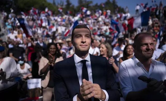 FILE - Acting head of the National Rally party Jordan Bardella applauds during a National Rally event in Frejus, France, Sunday, Sept. 12, 2021. At just 28 years old, Jordan Bardella has led the French far right to a landslide victory in the European Parliament election in June. After voters propelled Marine Le Pen's National Rally to a strong lead in the first round of national legislative elections on Sunday, Bardella has turned to rallying supporters to grant Marine Le Pen's party an absolute majority in the decisive round of voting on July 7 and make him the prime minister of France. (AP Photo/Daniel Cole, File)