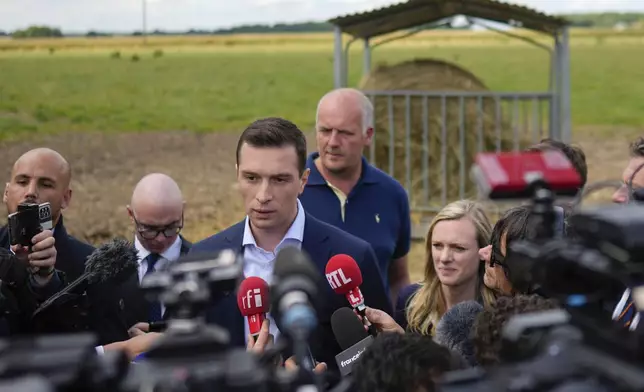 FILE - Jordan Bardella far-right National Rally leader for the upcoming election speaks to the media as he visits a farm in Chuelles, 137 kms (85 mls) south of Paris, Friday, June 14, 2024. At just 28 years old, Jordan Bardella has led the French far right to a landslide victory in the European Parliament election in June. After voters propelled Marine Le Pen's National Rally to a strong lead in the first round of national legislative elections on Sunday, Bardella has turned to rallying supporters to grant Marine Le Pen's party an absolute majority in the decisive round of voting on July 7 and make him the prime minister of France. (AP Photo/Thibault Camus, File)