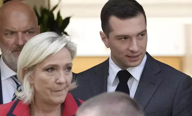 FILE - Far-right National Rally party president Jordan Bardella, right, leaves with far-right leader Marine Le Pen after a press conference, Monday, June 24, 2024 in Paris. Both Le Pen and Bardella have made clear that, in power, they would seek to rein-in Macron and exert themselves in defense, European and foreign affairs decision-making. (AP Photo/Christophe Ena, File)