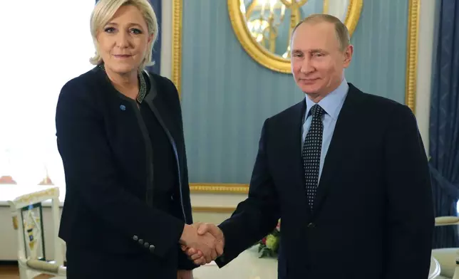 FILE - Russian President Vladimir Putin, right, shakes hands with French far-right presidential candidate Marine Le Pen, in the Kremlin in Moscow, Russia, Friday, March 24, 2017. On June 9, the French far-right National Rally trounced Macron’s party in elections for the European Parliament. The party has historically been close to Russia: one of its leading figures, Marine Le Pen, cultivated ties to Putin for many years and supported Russia’s illegal annexation of Crimea from Ukraine in 2014. (Mikhail Klimentyev, Sputnik, Kremlin Pool Photo via AP, File)