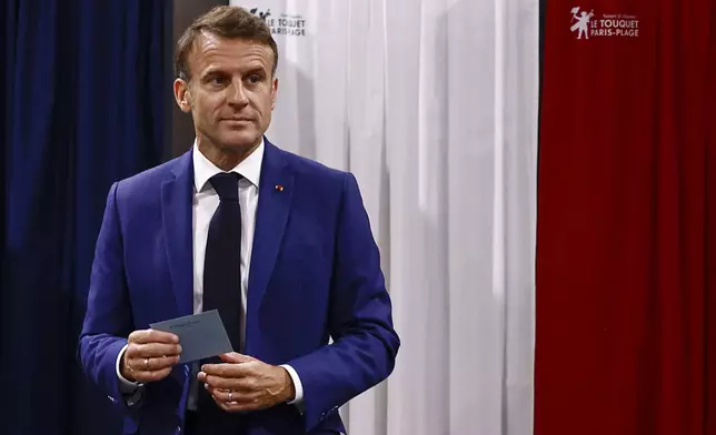 FILE - French President Emmanuel Macron leaves the voting booth before voting in the early French parliamentary election, in Le Touquet-Paris-Plage, northern France, Sunday, June 30, 2024. Whatever the outcome of Sunday's runoff is, it's not expected to be a good news for Macron. French media have recently described an "end of reign" atmosphere at the Elysee presidential palace. (Yara Nardi, Pool via AP, File)