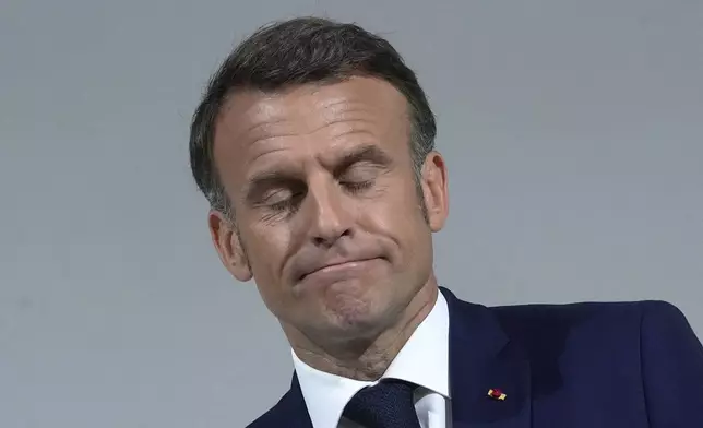 FILE - French President Emmanuel Macron reacts as he delivers a speech, Wednesday, June 12, 2024 in Paris. French President Emmanuel Macron's expected political failure in decisive parliamentary elections Sunday may paralyze the country, weaken him abroad and overshadow his legacy, just as France is about to be in the global spotlight as host of the Paris Olympics. (AP Photo/Michel Euler, File)