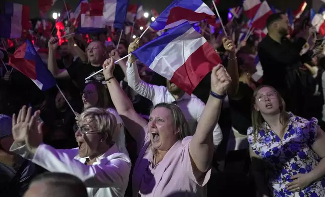 Supporters of French far right leader Marine Le Pen react after the release of projections based on the actual vote count in select constituencies in Henin-Beaumont, northern France, Sunday, June 30, 2024. (AP Photo/Thibault Camus)