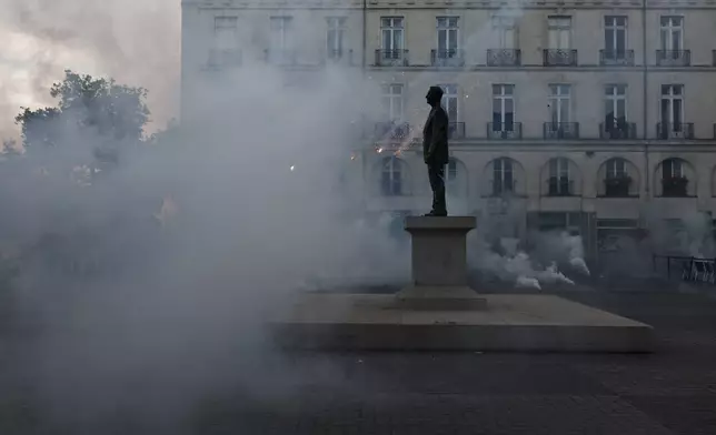 Demonstrators set off smoke flares as they react to projected results after the second round of the legislative elections, Sunday, July 7, 2024 in Nantes, western France. Polls have closed in France, and polling projections say a coalition on the left that came together unexpectedly has won the most parliamentary seats in the pivotal runoff elections after a high turnout among voters. (AP Photo/Jeremias Gonzalez)