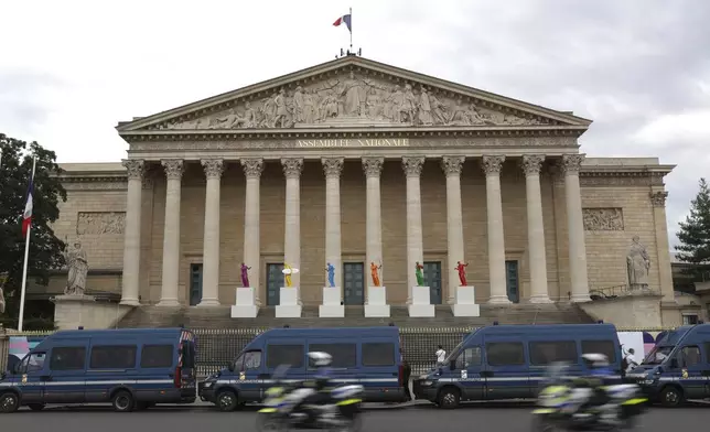 Police vans park outside the National Assembly during the second round of the legislative elections, Sunday, July 7, 2024 in Paris. France votes Sunday in pivotal runoff elections that could hand a historic victory to Marine Le Pen's far-right National Rally and its inward-looking, anti-immigrant vision — or produce a hung parliament and years of political deadlock. (AP Photo/Aurelien Morissard)