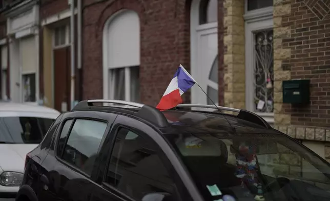 A French flag is attached to a car's antenna in Henin-Beaumont, northern France, Sunday, June 30, 2024. In the former mining town at the heart of French far-right leader Marine Le Pen's long-term political strategy, her party's electoral success Sunday came as no surprise to hundreds of supporters who gathered to see her victory speech. (AP Photo/Thibault Camus)