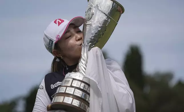 Ayaka Furue, of Japan, kisses her trophy after winning the Evian Championship women's golf tournament, in Evian, eastern France, Sunday, July 14, 2024. (AP Photo/Laurent Cipriani)