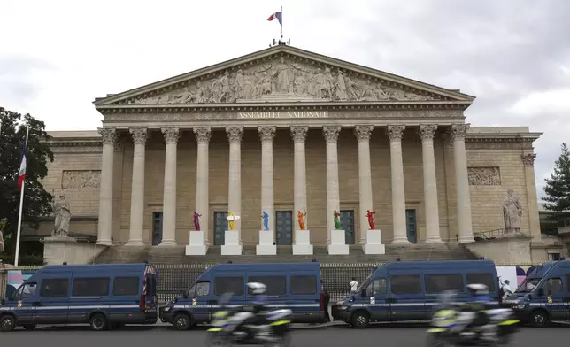 FILE - Police vans park outside the National Assembly during the second round of the legislative elections in Paris, Sunday, July 7, 2024. France’s far right leader Marine Le Pen says the country is “in a quagmire” after the chaotic legislative elections have produced a fragmented parliament and a deeply divided society as Paris prepares to host the Olympic Games at the end of the month. (AP Photo/Aurelien Morissard, File)