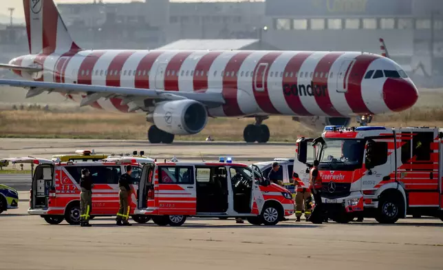 Emergency vehicles stand on a runway at the airport in Frankfurt, Germany, Thursday, July 25, 2024, after a few climate activists glued themselves to the ground blocking air traffic for several hours. (AP Photo/Michael Probst)