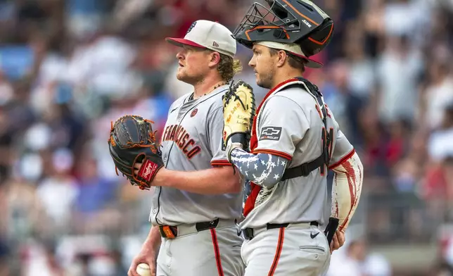 San Francisco Giants pitcher Logan Webb meets with San Francisco Giants catcher Patrick Bailey on the mound during the fifth inning of a baseball game against the Atlanta Braves, Thursday, July 4, 2024, in Atlanta. (AP Photo/Jason Allen)