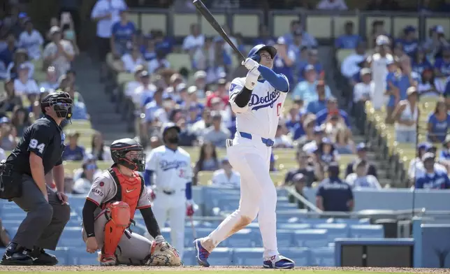 Los Angeles Dodgers designated hitter Shohei Ohtani, right, hits a home run during the eighth inning of a baseball game against the San Francisco Giants in Los Angeles, Thursday, July 25, 2024. (AP Photo/Eric Thayer)