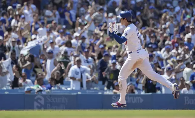 Los Angeles Dodgers designated hitter Shohei Ohtani celebrates while running the bases after hitting a home run during the eighth inning of a baseball game against the San Francisco Giants in Los Angeles, Thursday, July 25, 2024. (AP Photo/Eric Thayer)