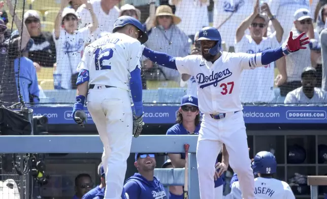 Los Angeles Dodgers' Teoscar Hernandez (37) congratulates teammate Nick Ahmed (12) for hitting a home run during the eighth inning of a baseball game against the San Francisco Giants in Los Angeles, Thursday, July 25, 2024. (AP Photo/Eric Thayer)