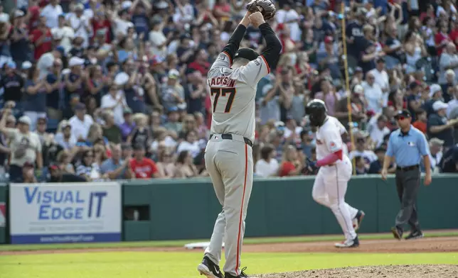 San Francisco Giants relief pitcher Luke Jackson (77) reacts as Cleveland Guardians' Jhonkensy Noel, rear, rounds the bases after hitting a solo home run during the fifth inning of a baseball game in Cleveland, Saturday, July 6, 2024. (AP Photo/Phil Long)