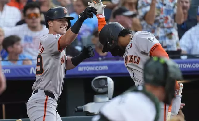 San Francisco Giants' Tyler Fitzgerald, left, celebrates after his solo home run with Luis Matos in the third inning of a baseball game against the Colorado Rockies Saturday, July 20, 2024, in Denver. (AP Photo/David Zalubowski)