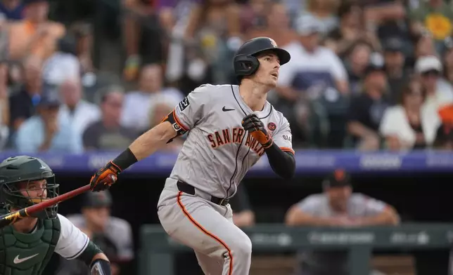 San Francisco Giants' Mike Yastrzemski follows the flight of his triple off Colorado Rockies starting pitcher Kyle Freeland in the fifth inning of a baseball game Saturday, July 20, 2024, in Denver. (AP Photo/David Zalubowski)