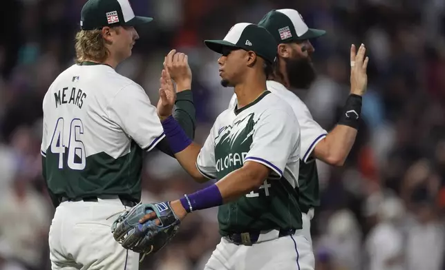 Colorado Rockies shortstop Ezequiel Tovar, center, is congratulated by relief pitcher Nick Mears, left, and Charlie Blackmon after a baseball game against the against the San Francisco Giants Saturday, July 20, 2024, in Denver. (AP Photo/David Zalubowski)