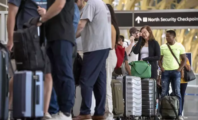 Travelers stand in line at a Delta Air Lines counter during a global technology outage at Reagan National Airport on Friday, July 19, 2024, in Arlington, Va. (AP Photo/Mark Schiefelbein)