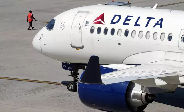 A Delta Air Lines jet leaves the gate during a global technology outage at Logan International Airport, Friday, July 19, 2024, in Boston. (AP Photo/Michael Dwyer)