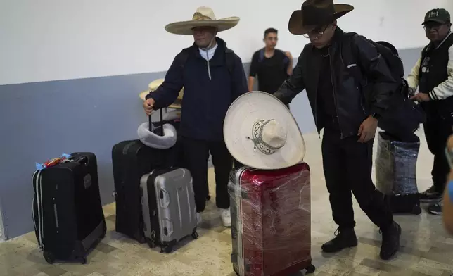 The folklore music group "Misquillahualy," from the Mexican state of Hidalgo, waits for a new flight to Colombia after theirs was canceled during a a global technology outage at Benito Juárez International Airport in Mexico City, Friday, July 19, 2024. (AP Photo/Marco Ugarte)