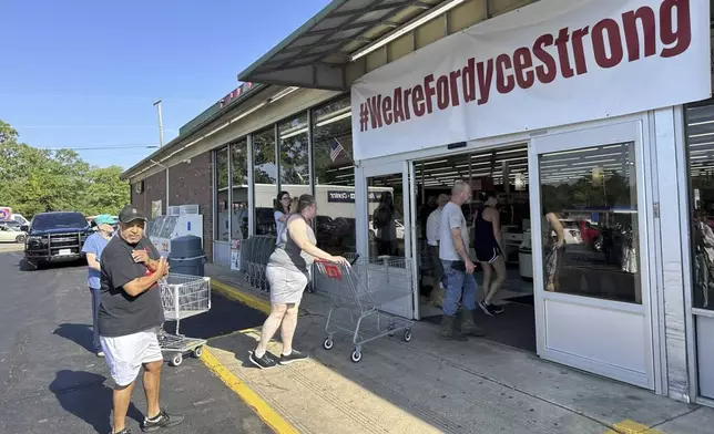 Shoppers enter the Mad Butcher grocery store in Fordyce, Arkansas on Tuesday, July 2, 2024. The grocery store reopened on Tuesday, 11 days after a mass shooting that killed four. (AP Photo/Andrew DeMillo)
