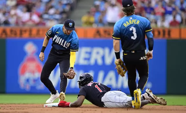 Cleveland Guardians' Angel Martínez (1) steals second base past Philadelphia Phillies' Trea Turner, left, and Bryce Harper (3) during the first inning of a baseball game, Friday, July 26, 2024, in Philadelphia. (AP Photo/Derik Hamilton)