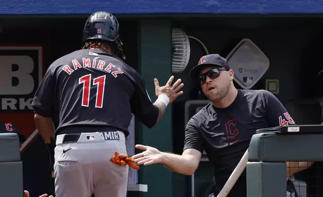 Cleveland Guardians Jose Ramirez (11) is congratulated by hitting coach Chris Valaika (45) after scoring off a Josh Naylor single during the eighth inning of a baseball game against the Kansas City Royals in Kansas City, Mo., Sunday, June 30, 2024. (AP Photo/Colin E. Braley)