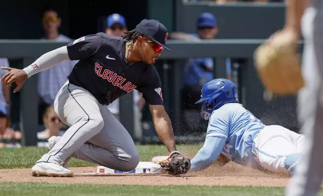 Kansas City Royals' Dairon Blanco, right, steals third base as Cleveland Guardians third baseman Jose Tena, left, attempts to make a tag without the ball during the fifth inning of a baseball game in Kansas City, Mo., Sunday, June 30, 2024. (AP Photo/Colin E. Braley)