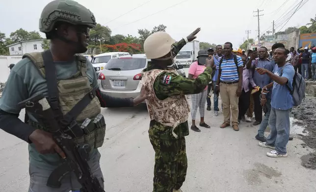 A Kenyan police officer takes candid photos of a group of Haitians welcoming the officers, in Port-au-Prince, Haiti, Wednesday, July 3, 2024. (AP Photo/Odelyn Joseph)