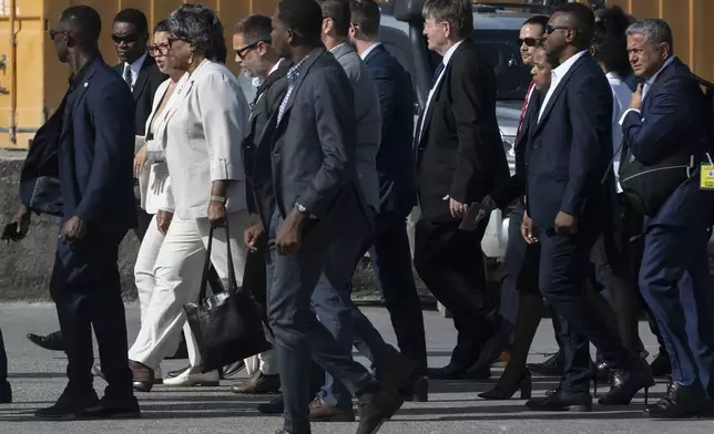 U.S. Ambassador to the United Nations Linda Thomas-Greenfield, front left, walks on the tarmac with Haitian Foreign Minister Dominique Dupuy, partially covered, after landing at Toussaint L'Overture International airport in Port-au-Prince, Haiti, Monday, July 22, 2024. (Roberto Schmidt/Pool via AP)